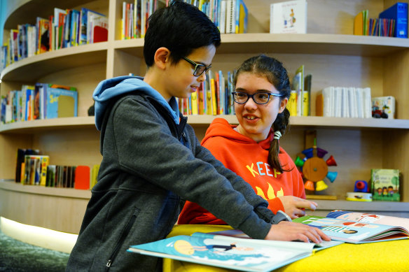 Mikail with Kala Petronijevic, 12, reading Australia’s first Braille books for children to be sold in bookstores. 