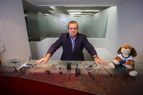 Mr Wilson shows various devices found to be used to monitor women by family violence perpetrators.