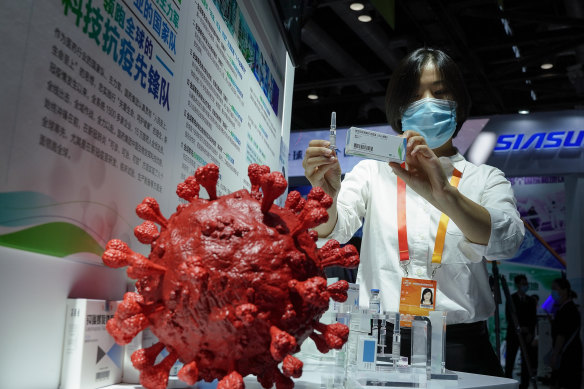 An employee displays a coronavirus vaccine candidate from China National Biotec Group (CNBG) at a trade fair in Beijing last month.