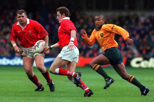 Jonathan Davies tries to beat a tackle by George Gregan in 1996.