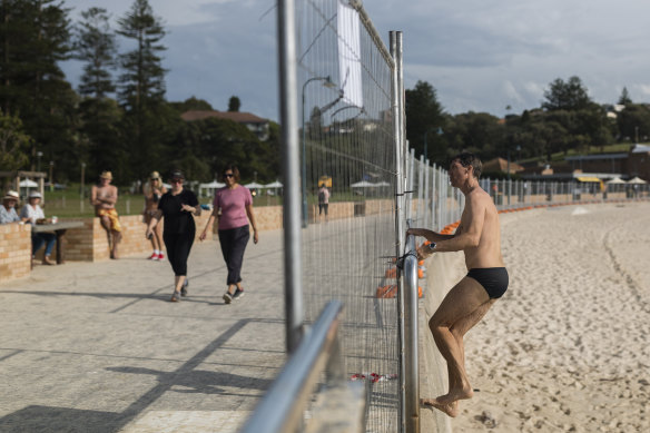 A man jumps the fence at Bronte beach to confront a photographer.