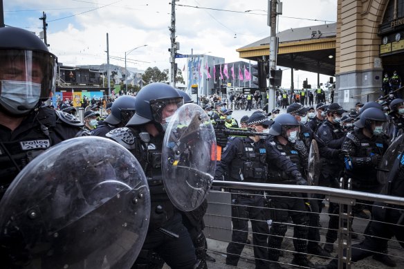 Police officers face protesters in Melbourne last year.