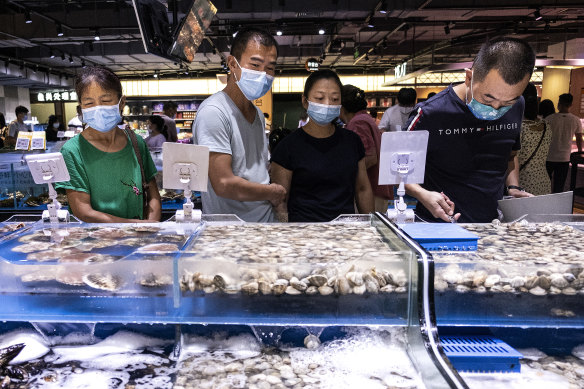 Masked market-goers in Wuhan, China. Authorities are trying to head off an outbreak of the scale seen in the central China city early last year. 