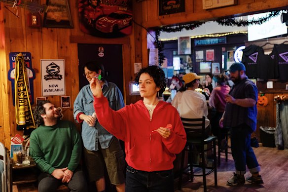 Phoebe Glick plays darts at another nightspot after finding Last Ditch closed for a private meeting on Saturday.