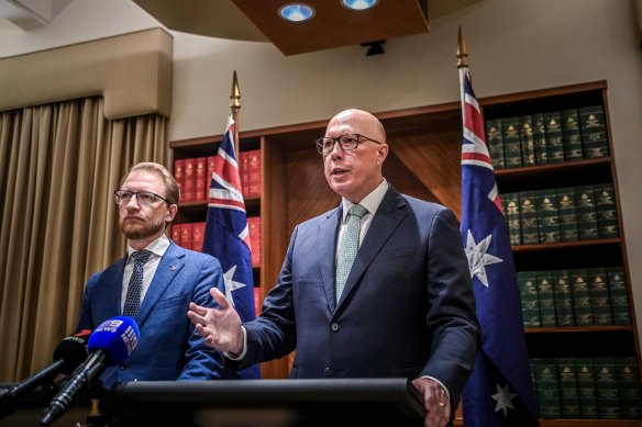 Opposition Leader Peter Dutton (right) and home affairs spokesperson James Paterson flanked by Australian flags at a press conference in Melbourne on Monday.