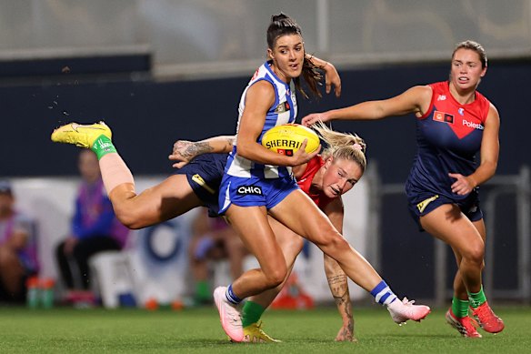 Kangaroo Erika O’Shea is tackled by Tayla Harris of the Demons.