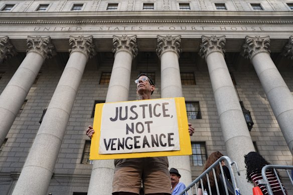 A man holds a sign outside Manhattan’s Federal Court. Inside, Luigi Mangione admitted to killing health insurance executive Brian Thompson.