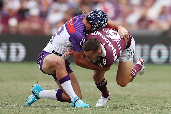 Melbourne half Jahrome Hughes tackles Manly’s Luke Brooks.