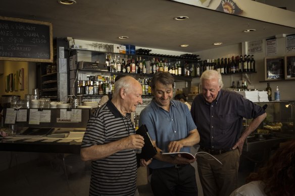 Peter Mills and Bruce Harvey of 2 Men Drawing, pictured with Mario Maccarone (centre), owner of Marios Cafe. 