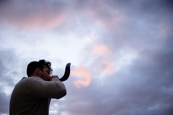 A man sounds the shofar, an ancient musical horn, at the Bondi Pavilion during a vigil on the third anniversary of the October 7 Hamas attack on Israel. 