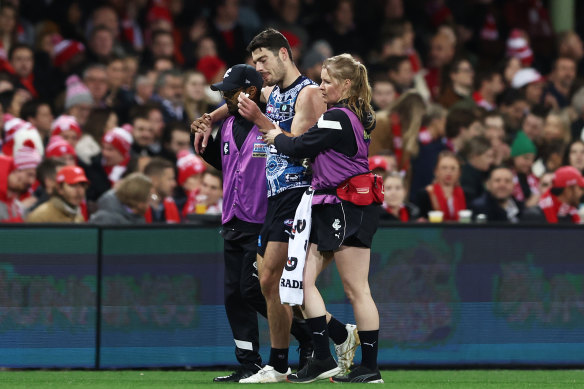 George Hewett is helped from the field.