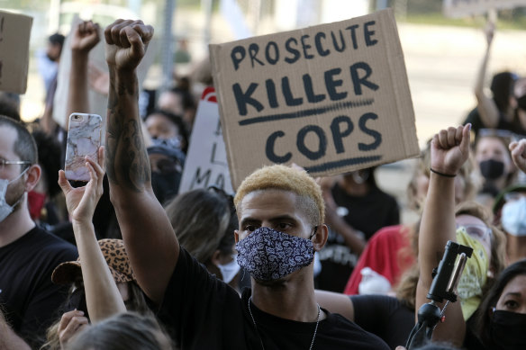 A demonstrator raises his fist during a protest of the death of George Floyd, a black man who was in police custody in Minneapolis, in downtown Los Angeles on Wednesday, May 27, 2020. 