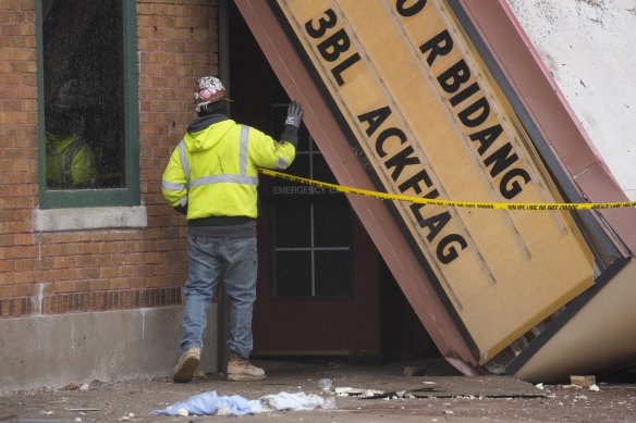 A worker inspects the collapsed marquee at the scene where the roof of the Apollo Theatre collapsed during a tornado.
