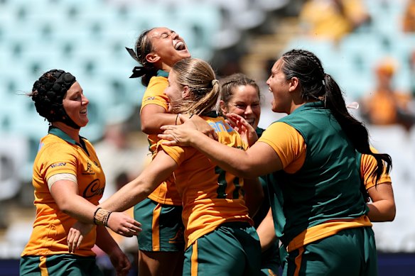 Amelia Whitaker of the Wallaroos is congratulated by teammates after scoring a try.
