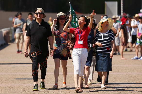 A guide points out the sights of Sydney to a group of Chinese tourists.