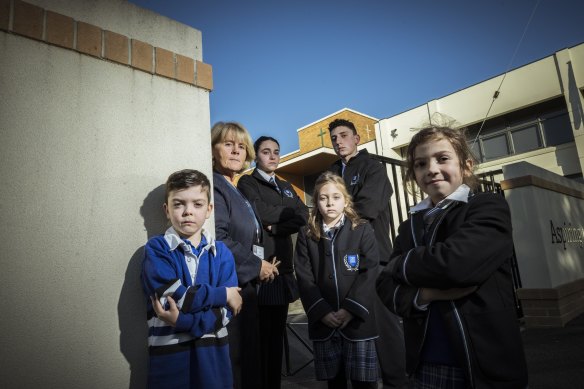 Alphington Grammar School principal Dr Vivianne Nikou stands with students Miles, Isabella, Zoe, Ethan and Nikoletta at the school gates. 