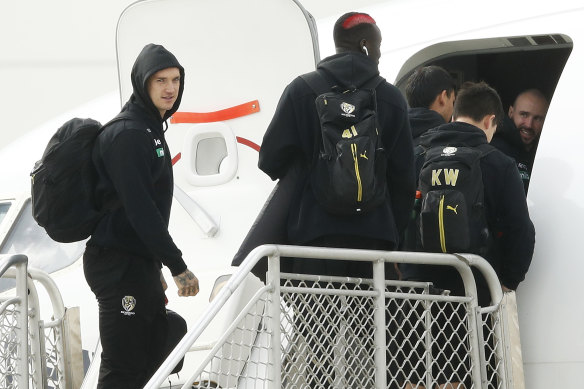 Dustin Martin and Richmond teammates board a flight at Melbourne airport on Monday.