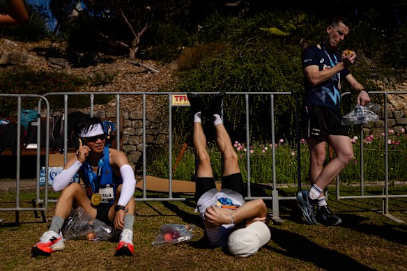 Athletes recover after finishing the Sydney Marathon.