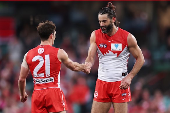 Brodie Grundy celebrates an Errol Gulden goal by shaking hands.