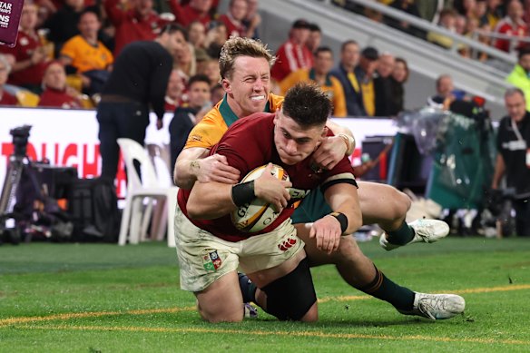 Dan Sheehan of British and Irish Lions goes over to score his team’s 3rd try despite the efforts of Harry Potter of Australia.