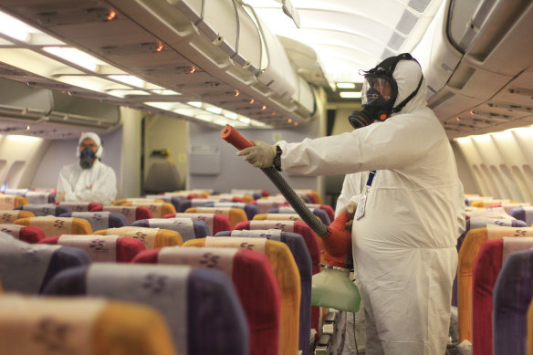 A worker sprays a Thai Airways aircraft. Thailand is opening up to tourists from China.