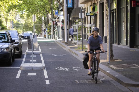 A woman rides on the separated new bike lane on Exhibition Street.