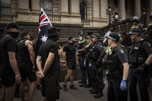 Members of a neo-Nazi group square off against police at an anti-trans rights rally outside Victoria’s parliament in March.