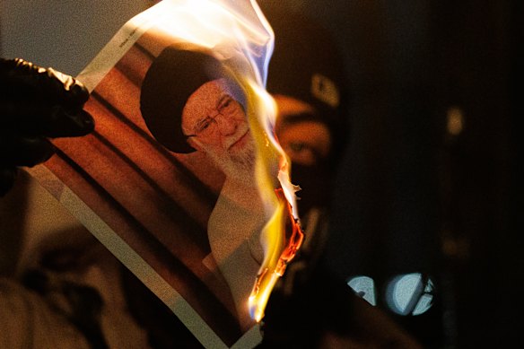 Un manifestante brucia un'immagine di Ali Khamenei durante una protesta davanti all'ambasciata iraniana il 14 gennaio.