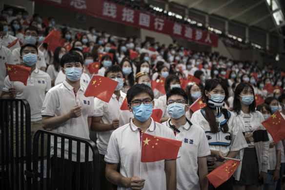 A group of seven thousand graduate students wear masks during the opening ceremony at Huazhong University of Science and Technology at the school's stadium on September 4 in Wuhan.