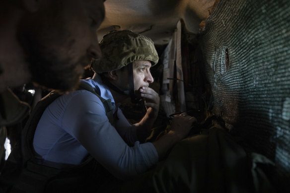 In an undated photo, President Volodymyr Zelenskyy looks at a front-line position from a shelter as he visits eastern Ukraine.