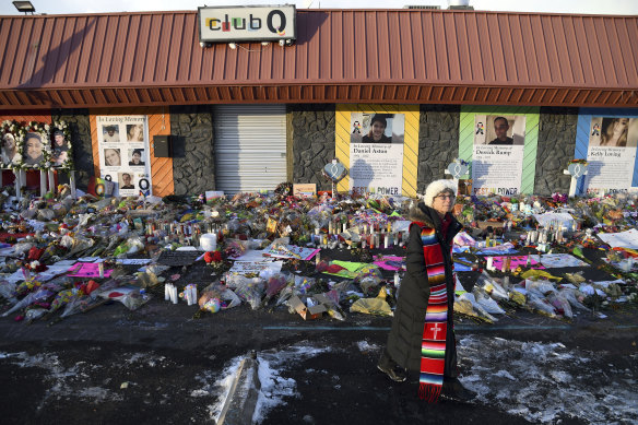 Reverend Paula Stecker of the Christ the King Lutheran Church stands in front of a memorial set up outside Club Q.  