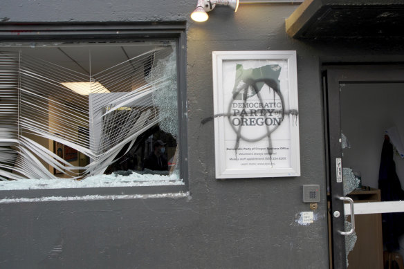 Protesters tag and smash windows at the Democratic Party of Oregon headquarters on Wednesday, January 20, in Portland. 