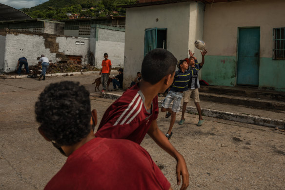 Children play rugby as members of the Alcatraz project repaint a school in Sabaneta, Venezuela.
