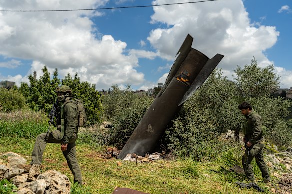 Tentara Israel berdiri dekat sebuah rudal Iran yang tertancap di tanah pada hari Selasa di desa Palestina Hares, Tepi Barat.