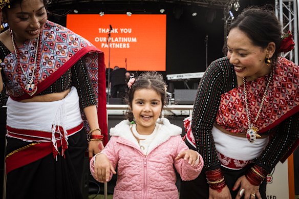 Divirtiéndose: Sehar Singh, 4 años, con bailarines nepaleses en el Momo Fest en Footscray.
