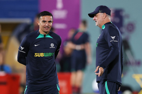 Graham Arnold speaks with Australia’s head of delegation in Qatar, Tim Cahill, whose retirement in part led to Arnold taking on an additional coaching role with the Olyroos.