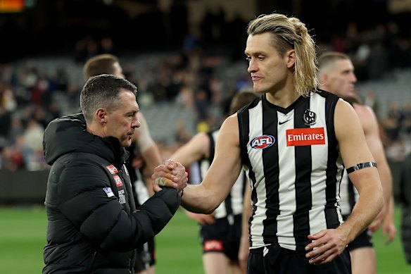 Craig McRae and Darcy Moore of the Magpies comfort each other post-game.