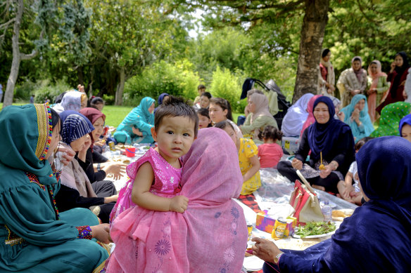 New beginning: Hazara women and children enjoy lunch the men cooked at Footscray Park.