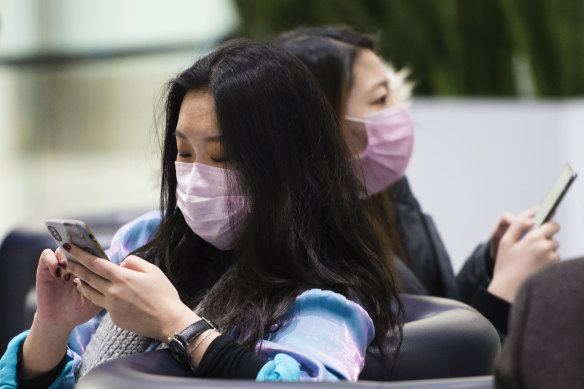 People wear masks at the International terminal at Toronto Pearson International Airport on Saturday, as it emerged the coronavirus had spread to Canada. 