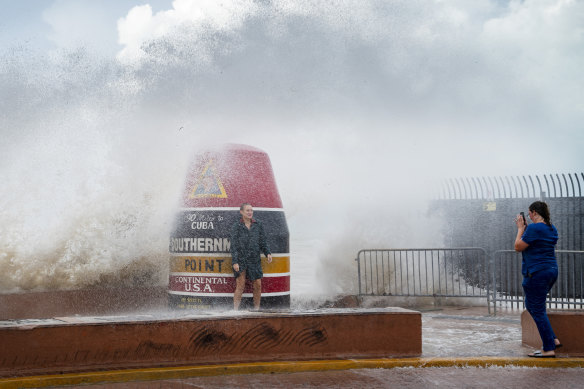 Visitors to the Southernmost Point buoy brave the waves made stronger from Hurricane Idalia.