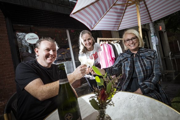 Matt McConnell from Bar Lourinhã, Jane Matthews from retailer Swensk, and lord mayor Sally Capp at a CBD parklet on a wet Melbourne day.
