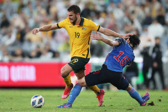 Gianni Stensness of the Socceroos is challenged by Takumi Minamino.