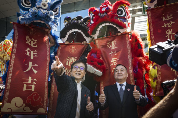 Action movie star Jackie Chan (left) takes in Melbourne’s Chinese dragon dancers.