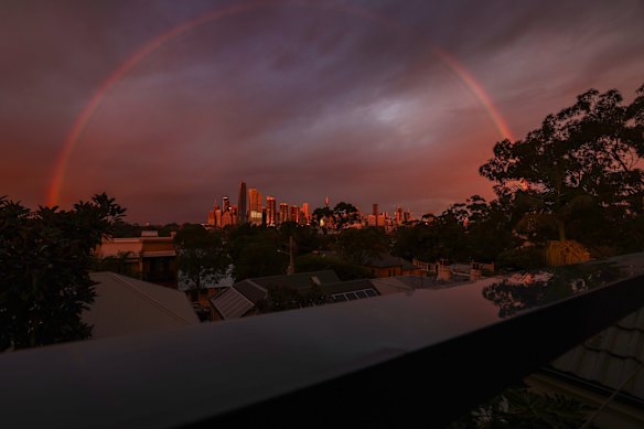 A rainbow is seen over Sydney during a break in the rain at sunset.