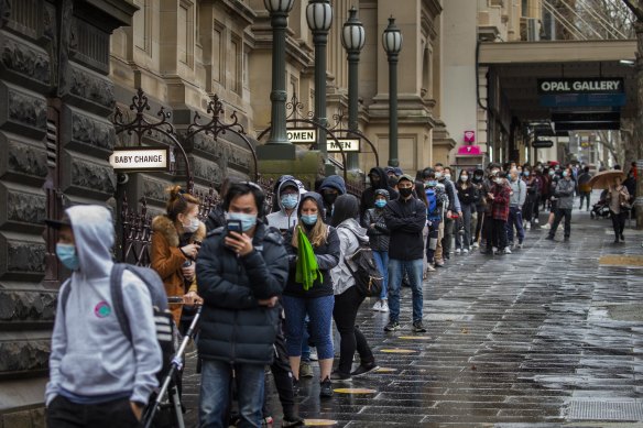 Huge lines of people wanting to get vaccinated against COVID-19 are seen at Melbourne Town Hall on Swanston Street on Friday.