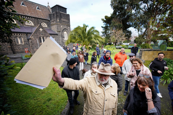 Patrick Casey leads protesters to the parish’s rectory.