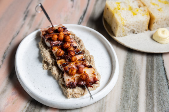 Octopus skewer topped with crisp chickpeas and laid over garlicky sausage puree.