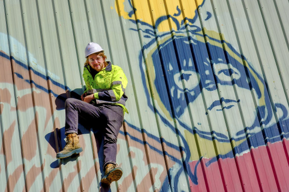 Artist Pat Perry with the mural he painted.