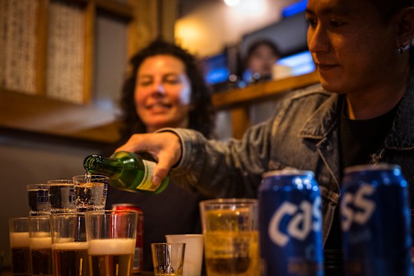 Mika Chae shows Dani Valent how to mix soju with beer, a popular beverage in Korea. 