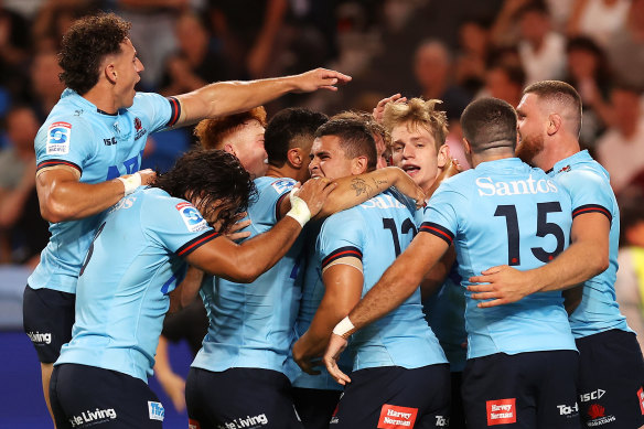Waratahs players swamp Max Jorgensen after he scores against the Brumbies.
